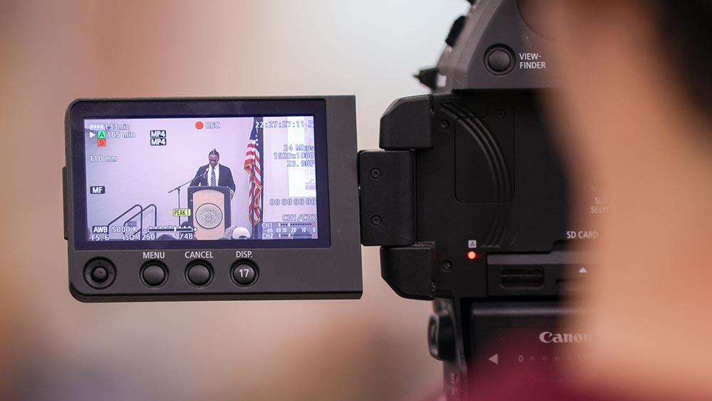 Blurred closeup of a person on a video camera focus on the camera screen