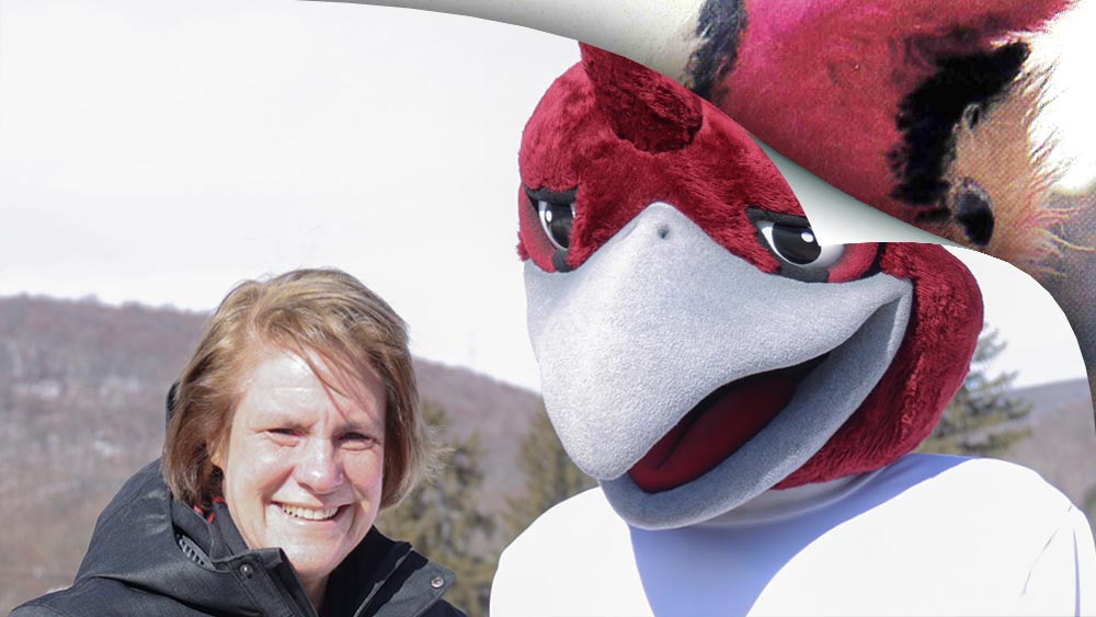 Ramapo College's President Jebb with Rock the roadrunner mascot with a edged turned over like a page revealing a hint of a student made mascot. 